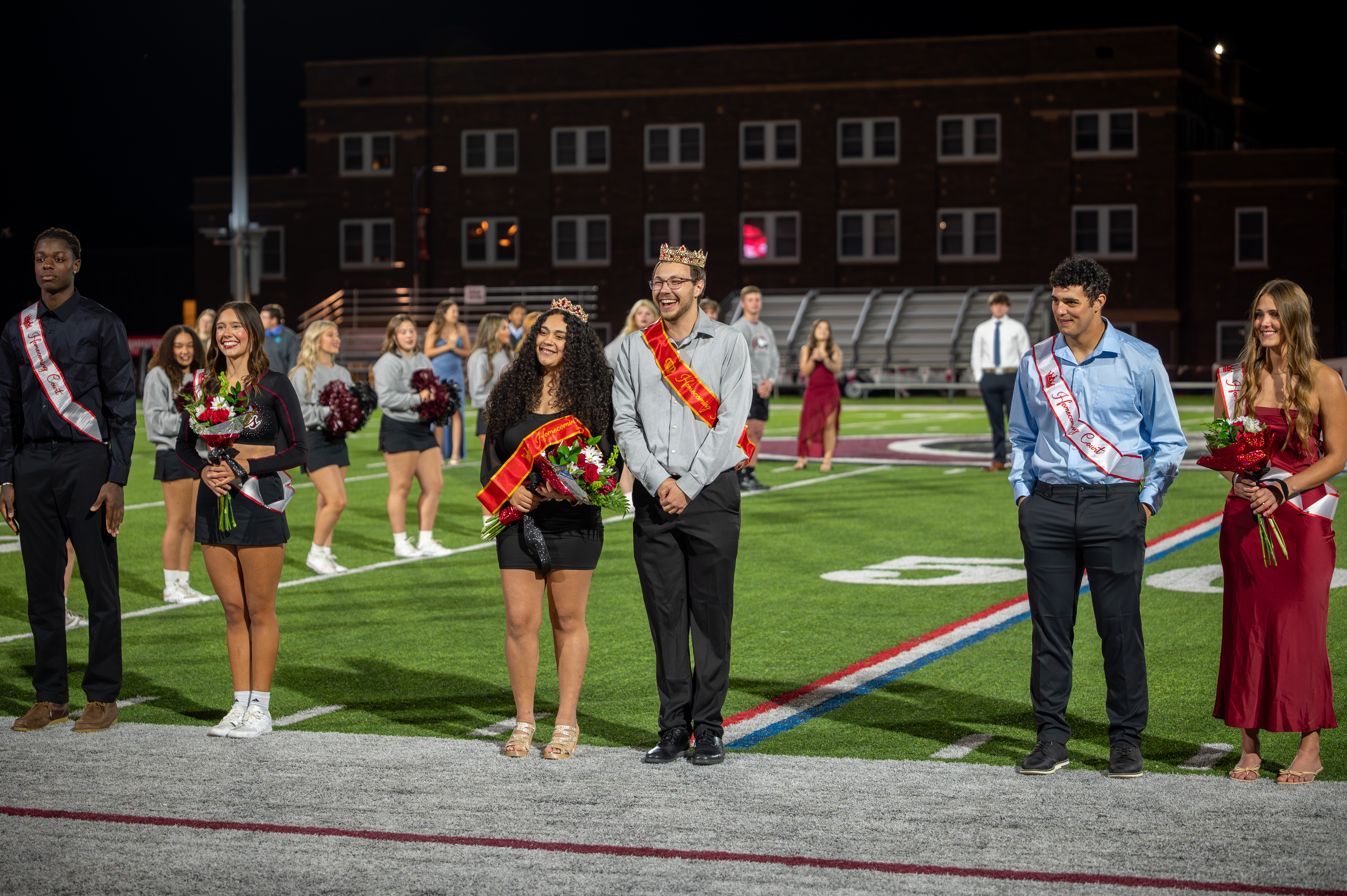 Homecoming royalty standing on football field