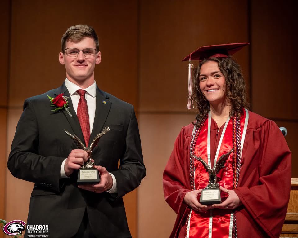 Two students posing with trophies