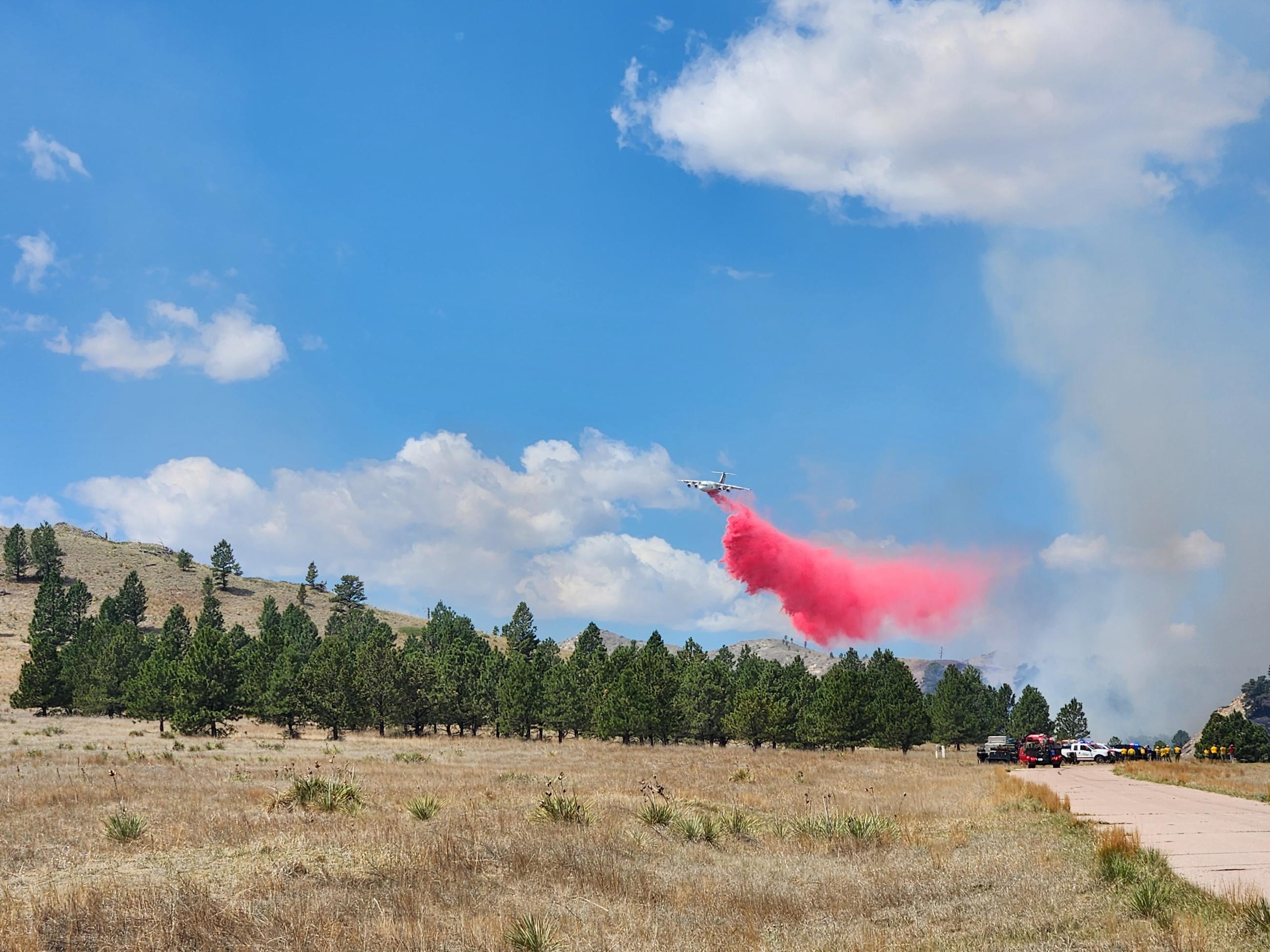Plane dropping fire retardant on fire