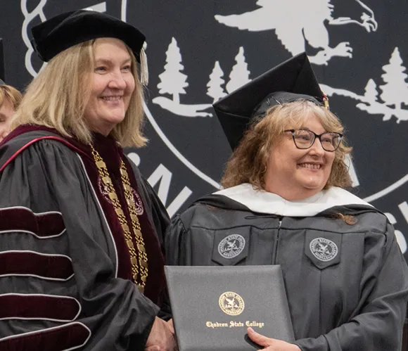 College president and graduate smiling