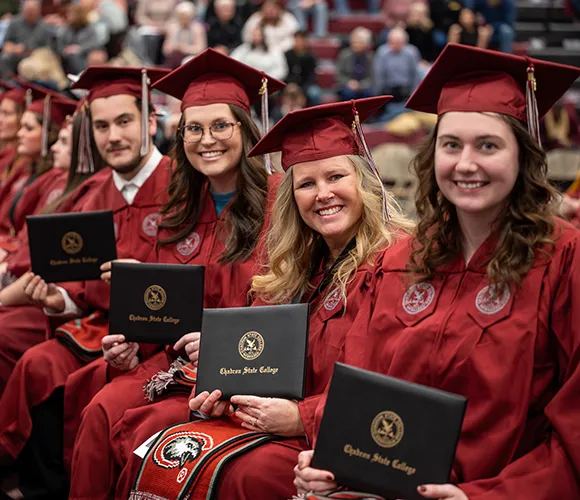 College graduates smiling with diplomas