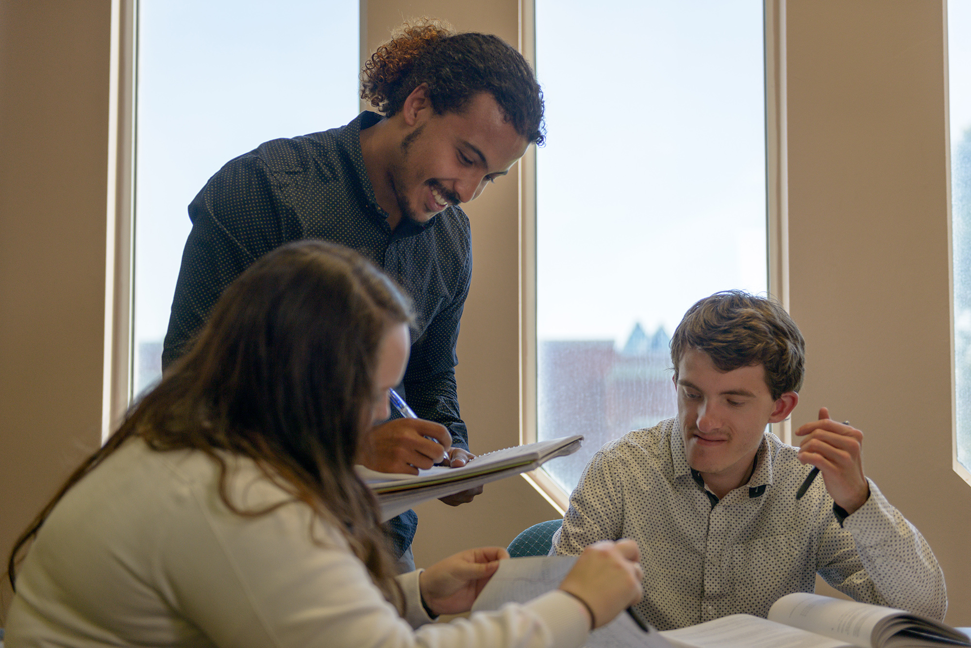 Tutor helping students in the library.